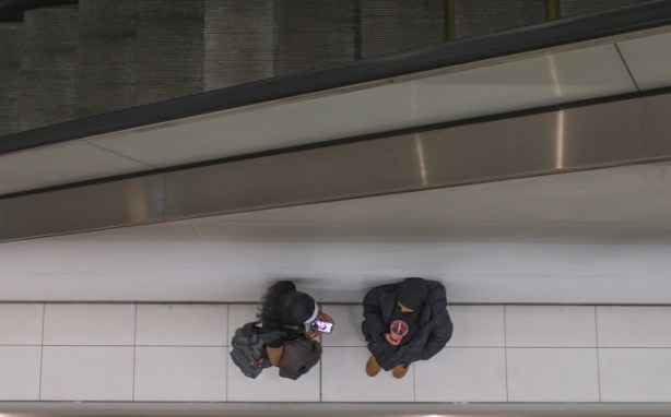 two women talking on LRT platform at the bottom of an escalator