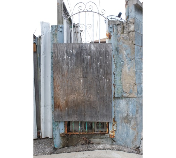 old gate, patched with pieces of plywood