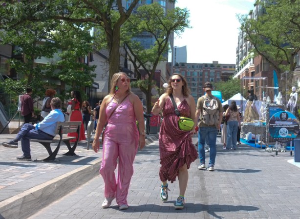 two women, both dressed in pink walking together down the street