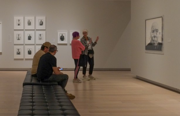 people looking at photographs in a gallery, black and white portraits by Richard Avedon