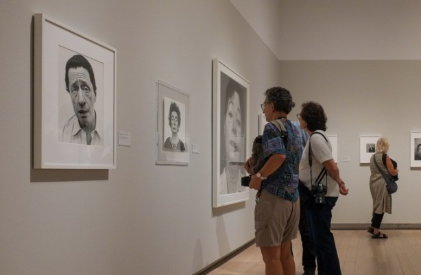 people looking at photographs in a gallery, black and white portraits by Richard Avedon