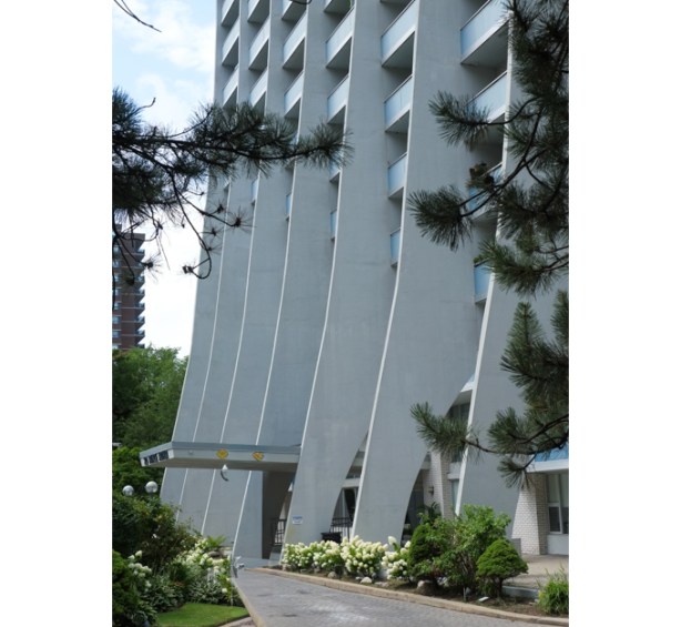 apartment building designed by architect Uno Prii, mid century, sweeping vertical supports curved at the bottom, 
