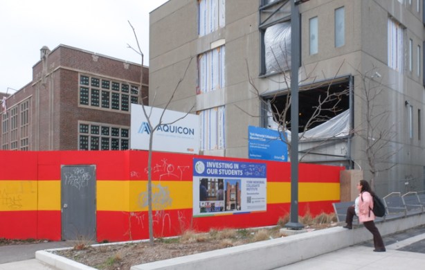 reconstruction of York Memorial Collegiate, with red and yellow hoardings around the school