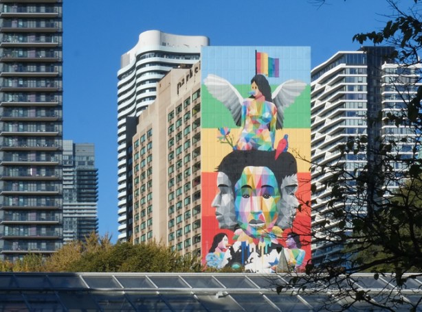 view over the top of one of the greenhouses in Allan Gardens, mural Equilibrium, other tall buildings,