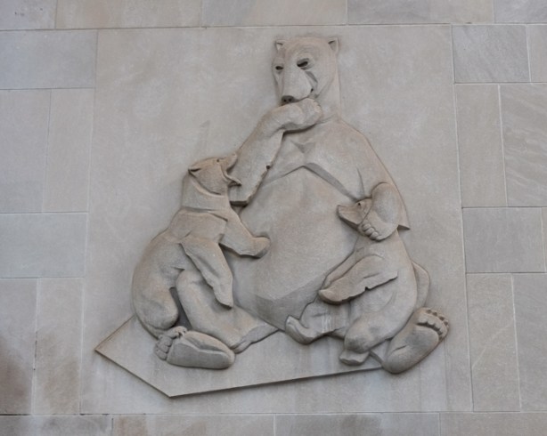 stone relief sculptures on side of building, bear family